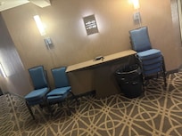 Stacks of chairs, random alarm clock, a pair of shoes & a big full garbage can just outside the elevator for two days