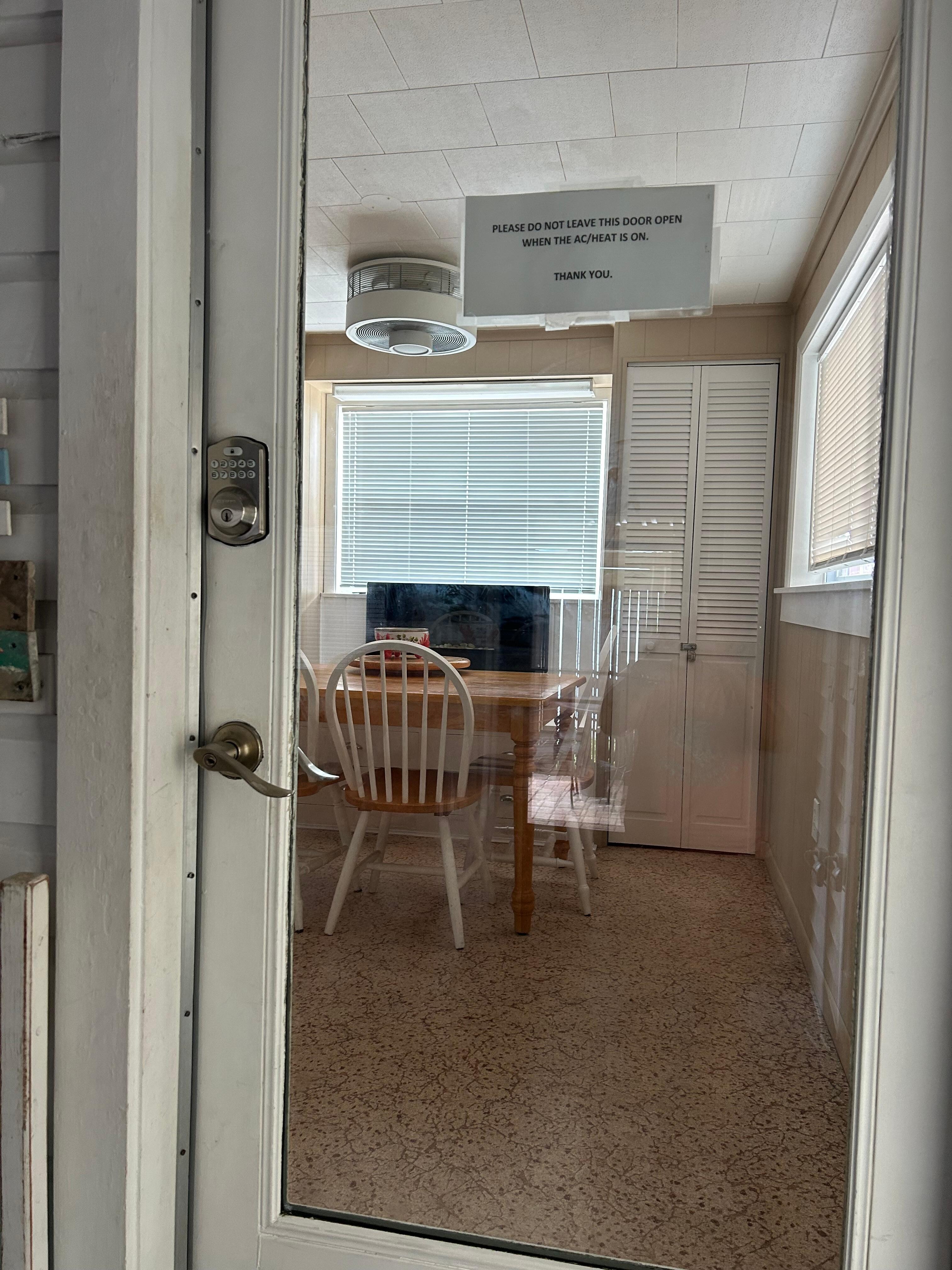 The coded entry door heading in to the dining and kitchen area.  Fireplace under the window, above a bench.