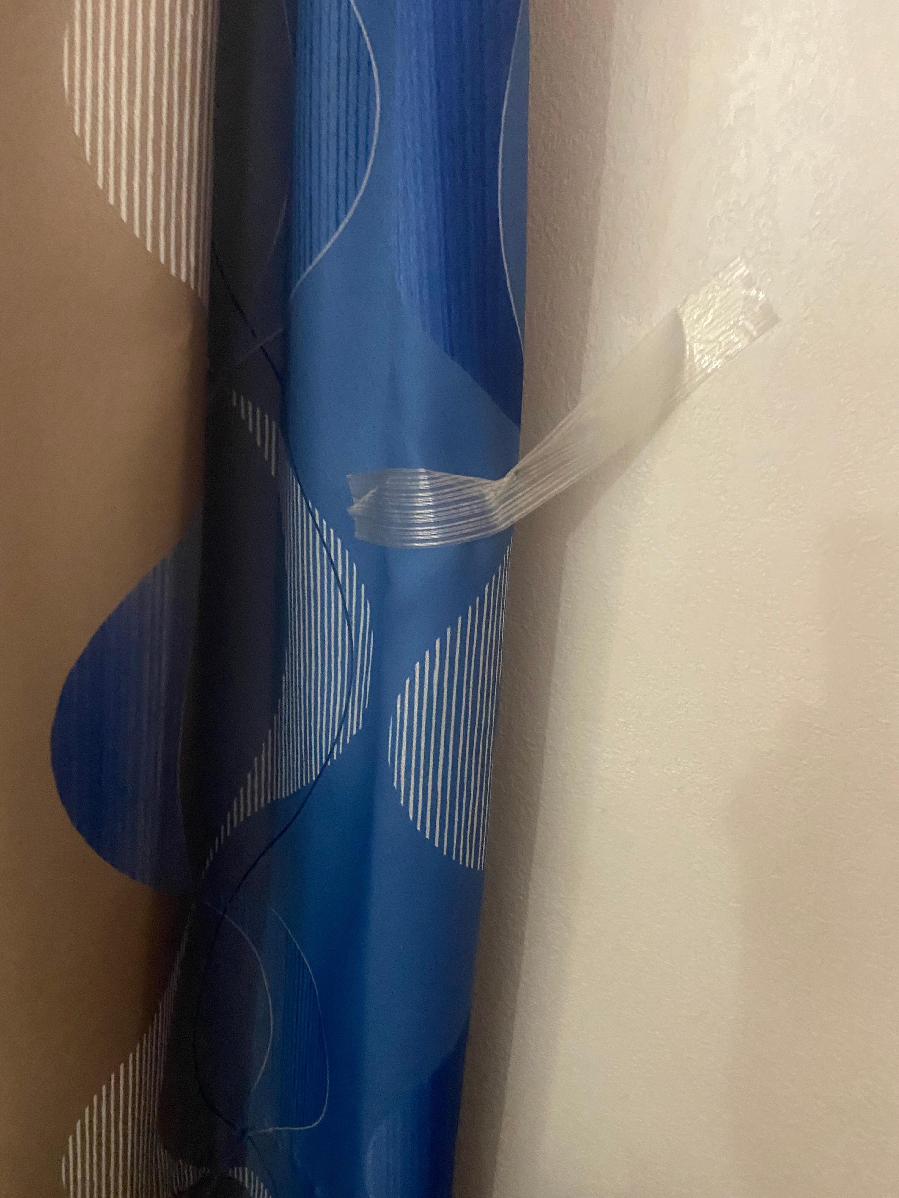 Curtains taped to the wall to hold in plaxe