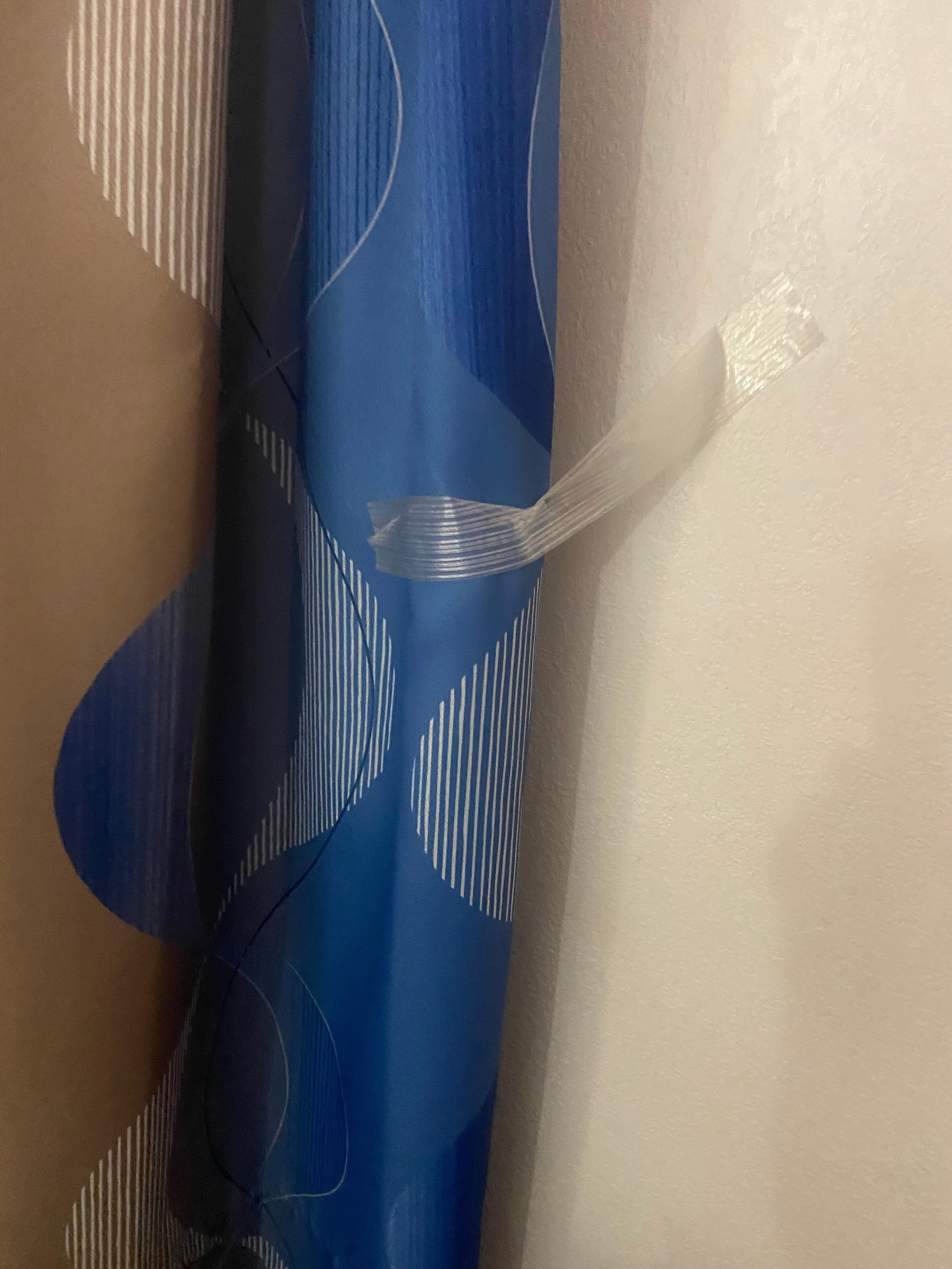 Curtains taped to the wall to hold in plaxe