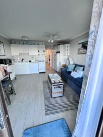 Balcony looking to interior - open concept with dishwasher and microwave, frige and freezer, stove and oven, large sink, nice countertop, mugs, dish pods and soap, paper towels, utensils, plates