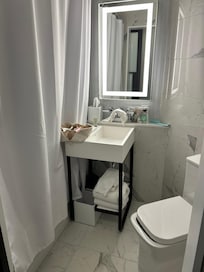 Toilet seat misaligned. Sink installed sideways to fit into the tiny bathroom.