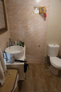 WC und Waschbecken mit Kaltwasser sind von der Dusche und einem weiteren Waschbecken mit warmen Wasser plus Waschmaschine getrennt.