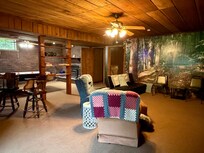 Family game room with seating for a good size crowd and playing games. Has door to go right outside to the fire pit and nice yard for some corn home and football