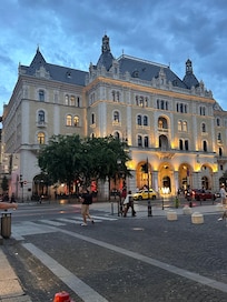 W hotel front view from across the road. Patio is sheltered under the portico but the sunshine reaches in and creates a warm atmosphere in the afternoon