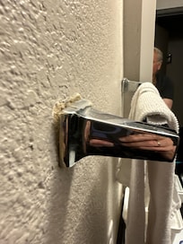 Towel rack about to fall off wall.