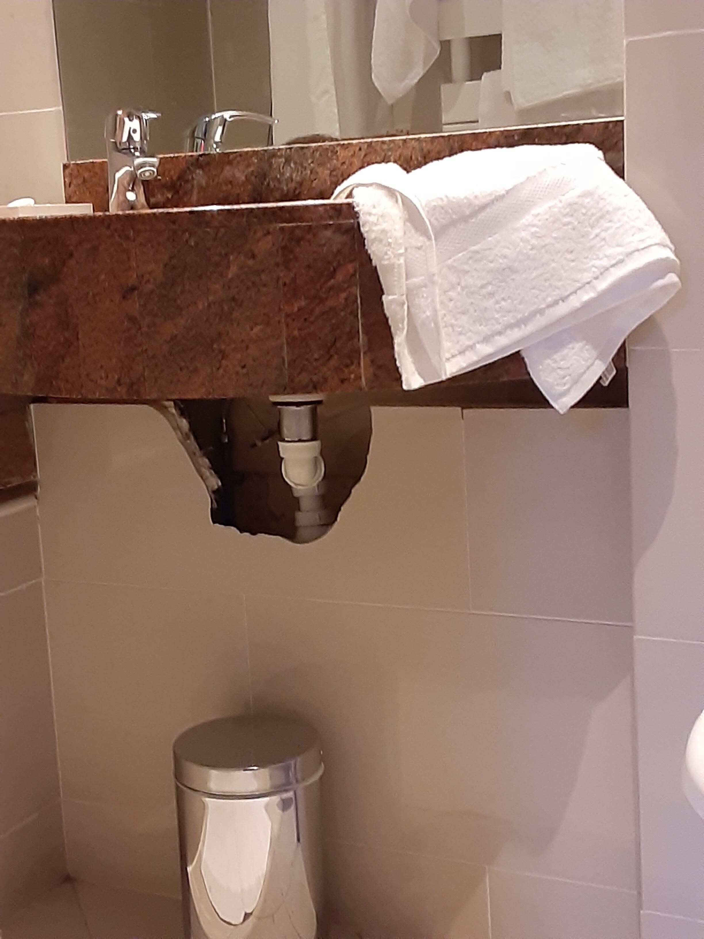 exposed pipes under bathroom sink in room 34