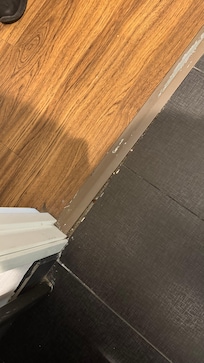 Bathroom door jam defect, hair and dust.