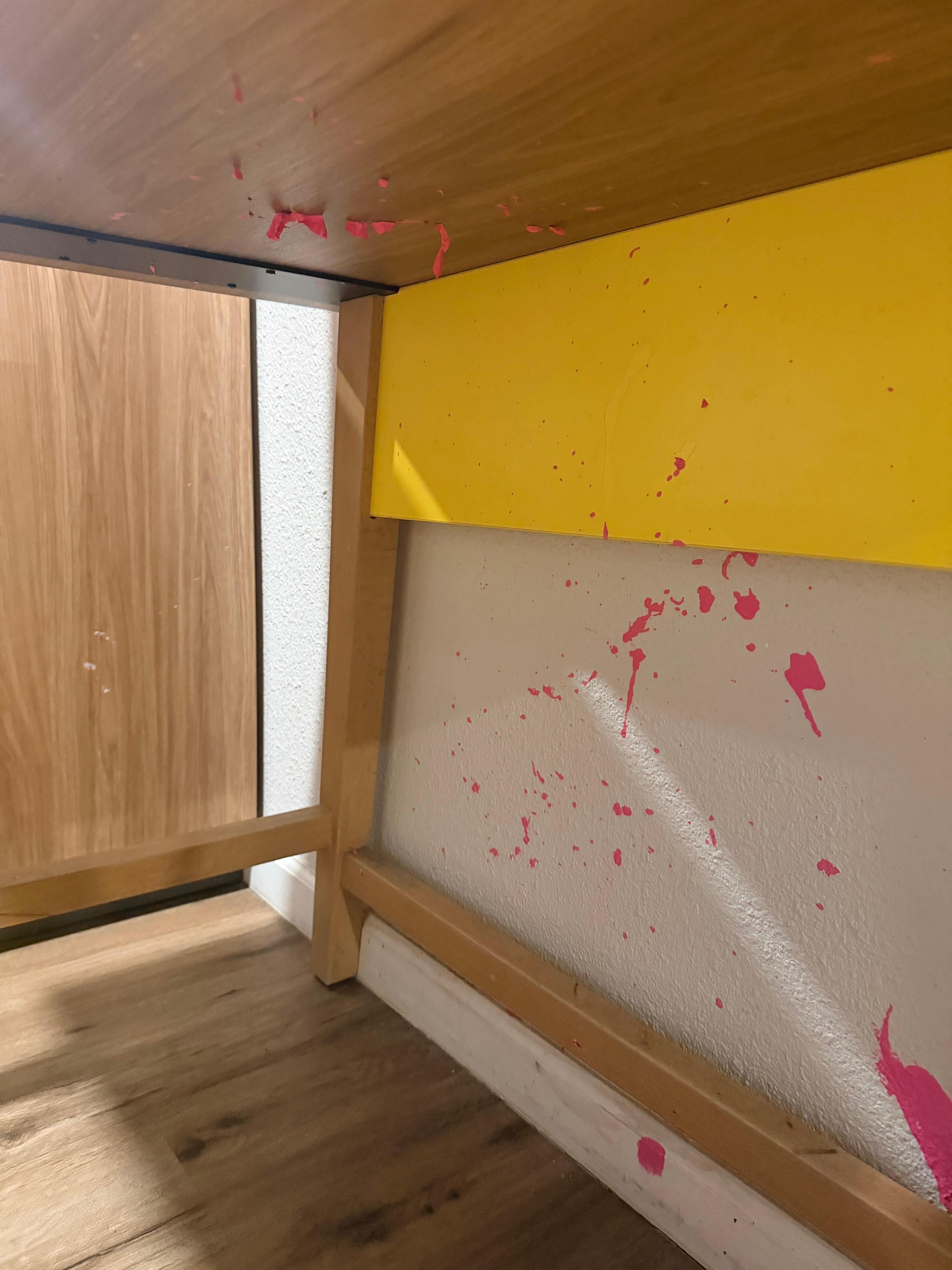Pink paint splatter on the wall and under the desk peeling—would’ve been so easy for them to wipe it off