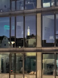 Reflection of Eiffel Tower in building windows across the street.