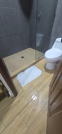 El baño sin puerta en la ducha ni cortina la puerta de entrada es todo lo que se habre el agua cae al piso
