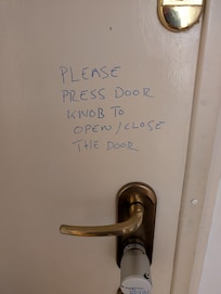 With luck, door will open when you press the white knob but it was unreliable. Note the care taken in scribbling the instructions!
