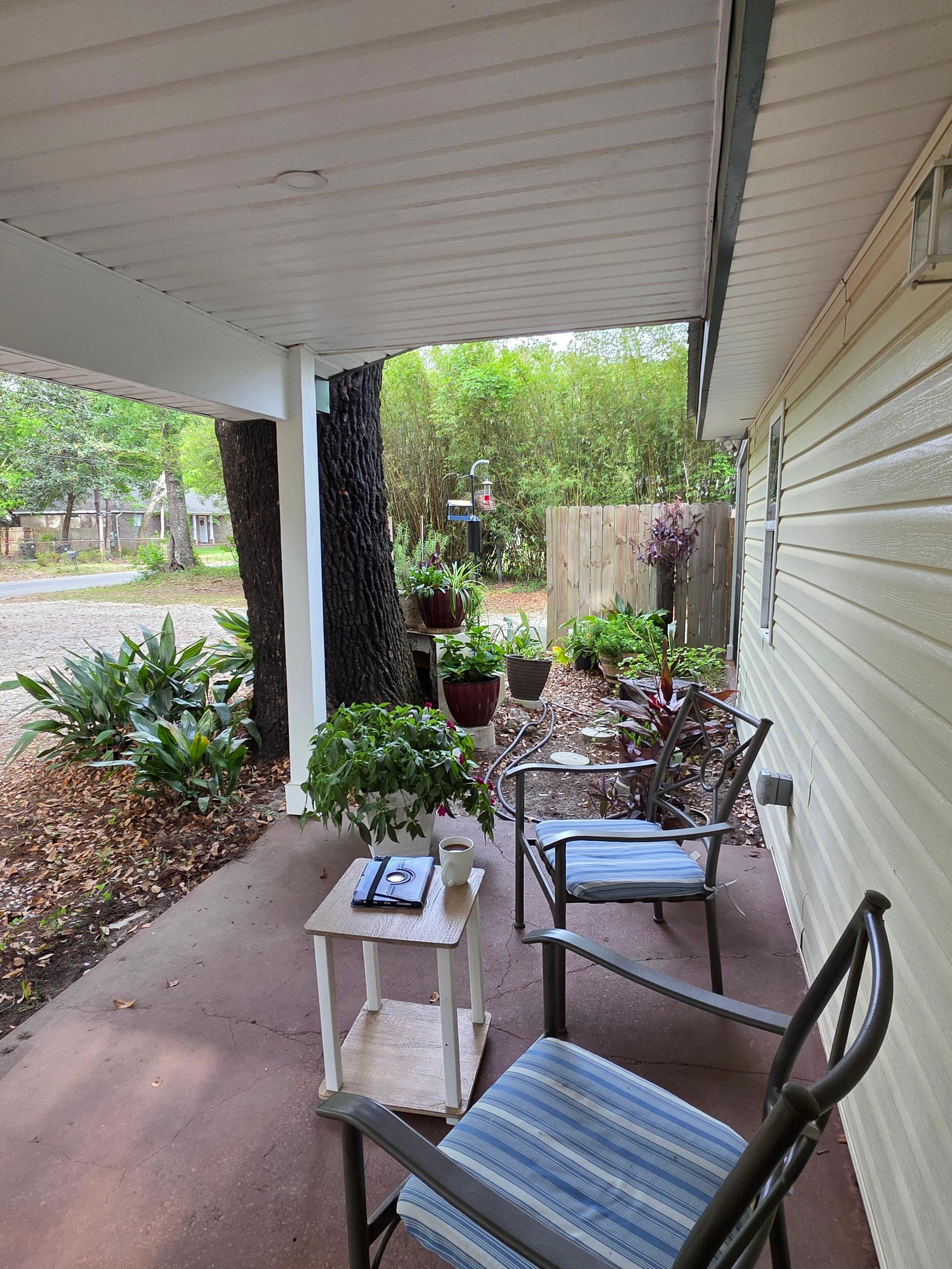 Little garden area with bird feeders next to the porch chairs