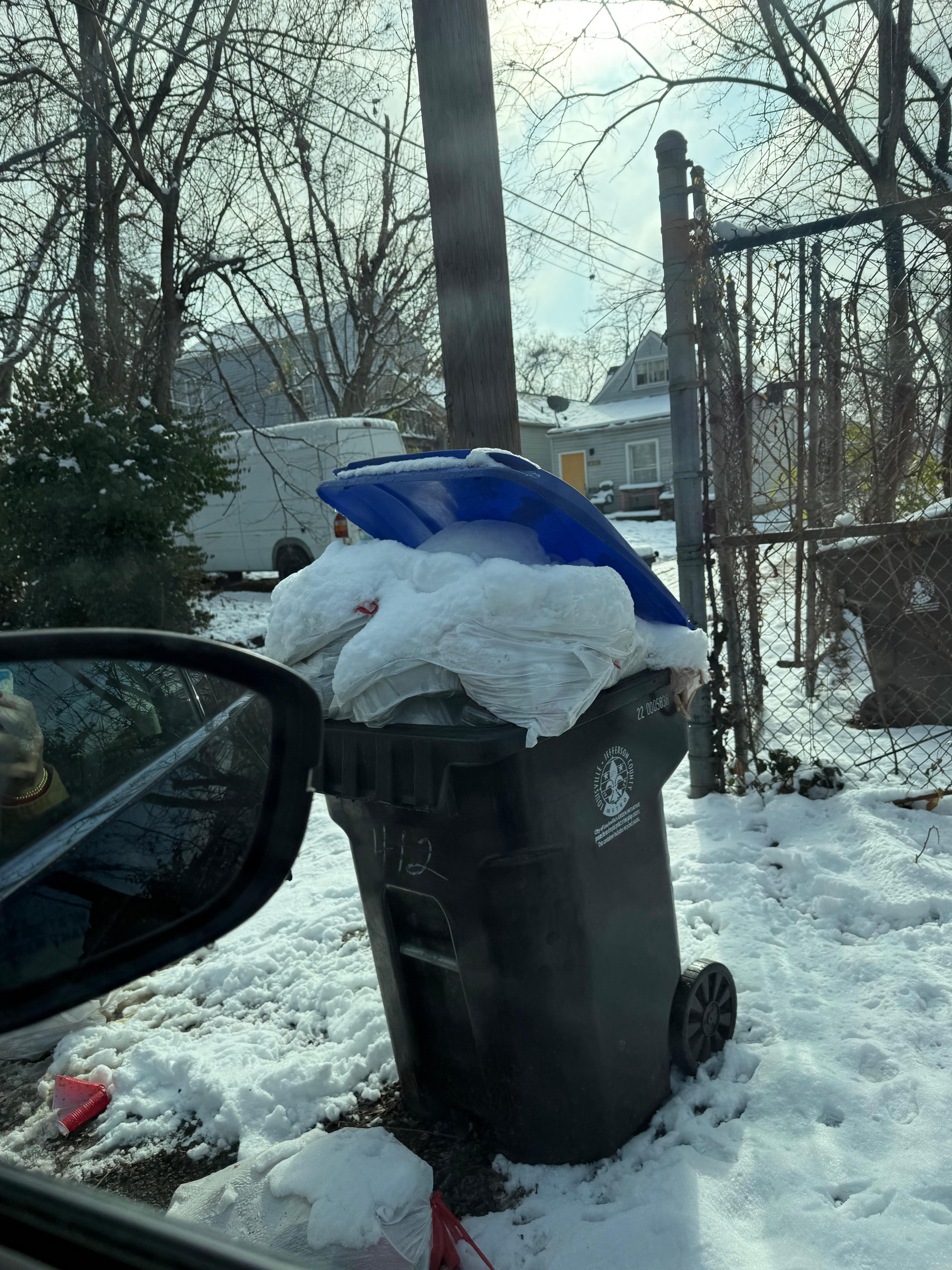 Garbage overflowing in front of gate and on road 