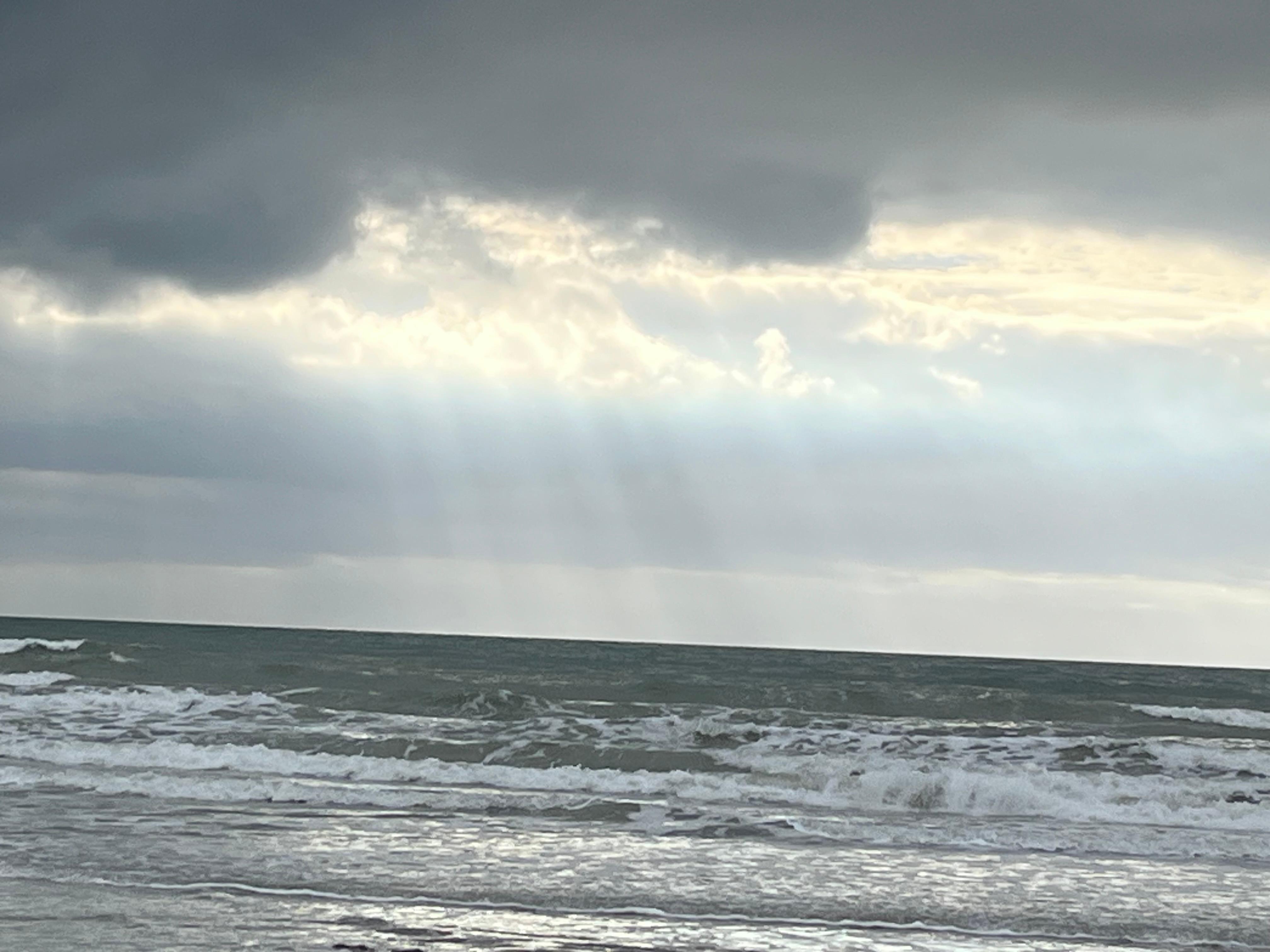 Sun through clouds from the beach 