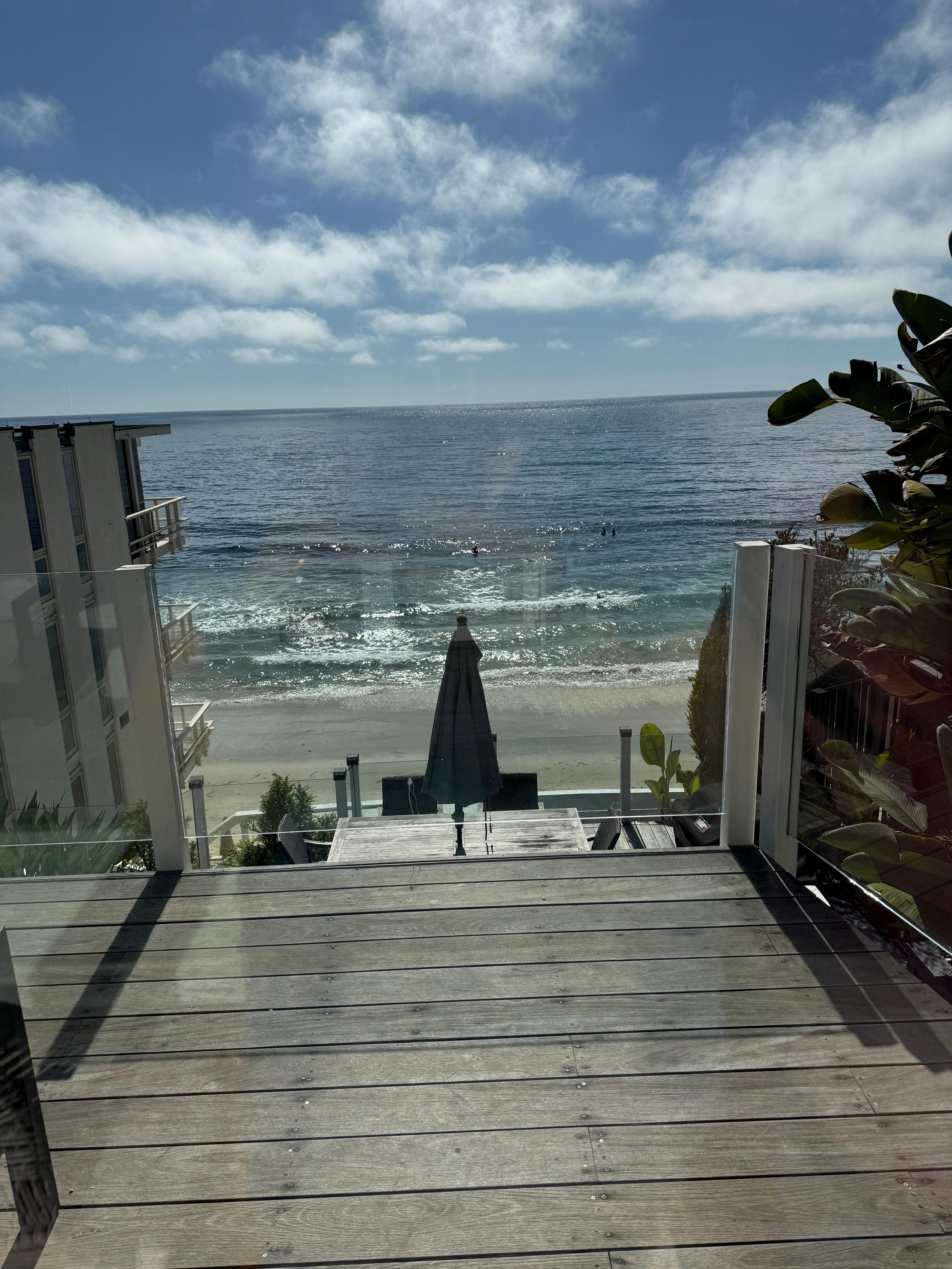 View from main floor of home looking from top balcony down to level where table and grill are located.