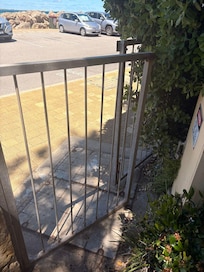 Unlocked side gate facing a public carpark. This leads to multiple apartment patios and anyone can walk in.