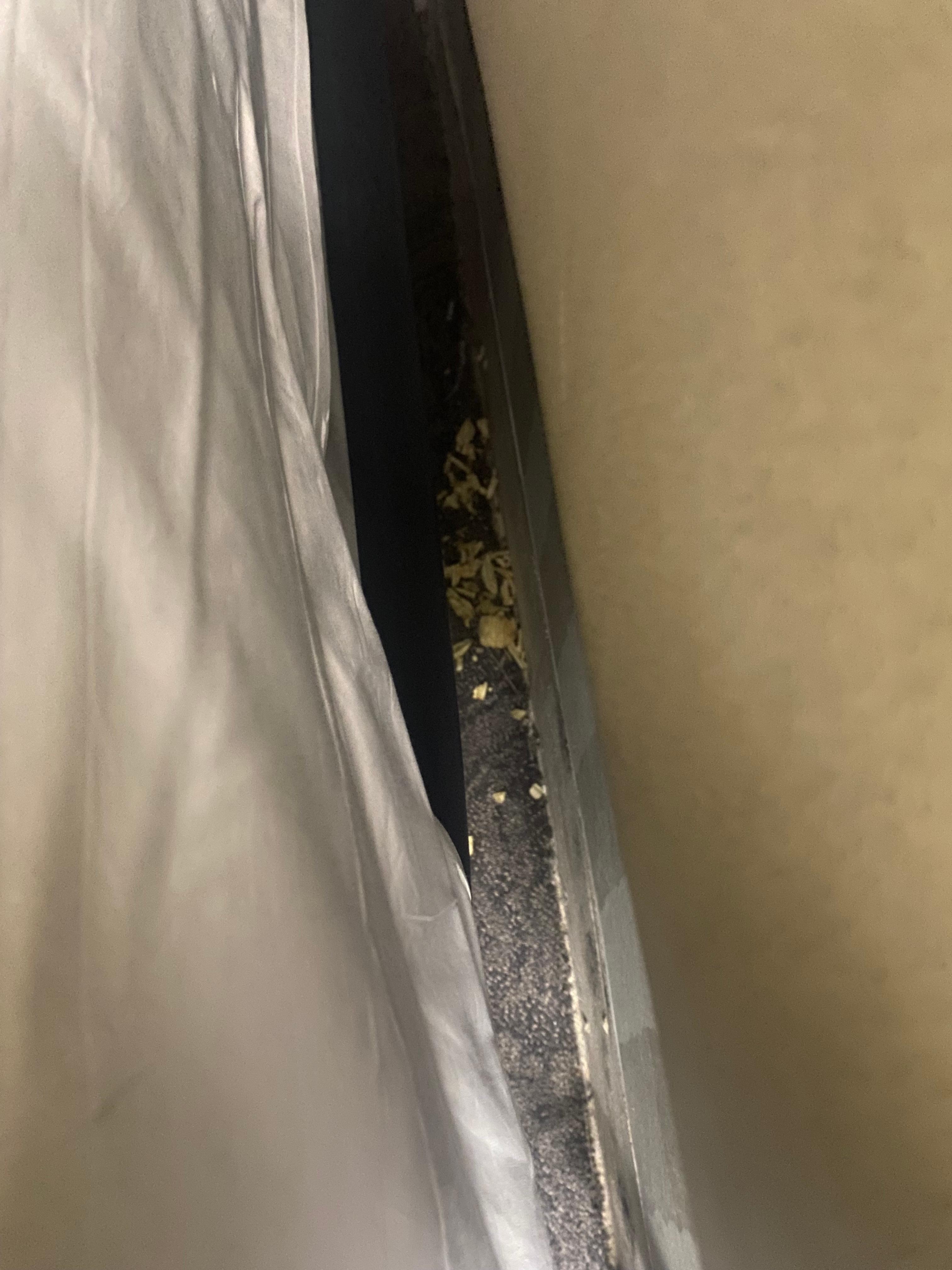 Chips/dirt found behind the bed frame (behind the head)