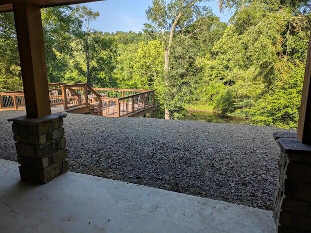 View from the back patio toward the deck and the river. Notice the drop-off.