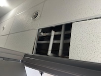 Pipes exposed on top of room door 102