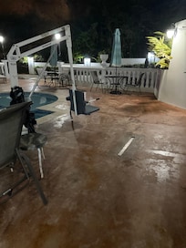 Plastic bags around handicap lift in pool and rusted furniture around pool
