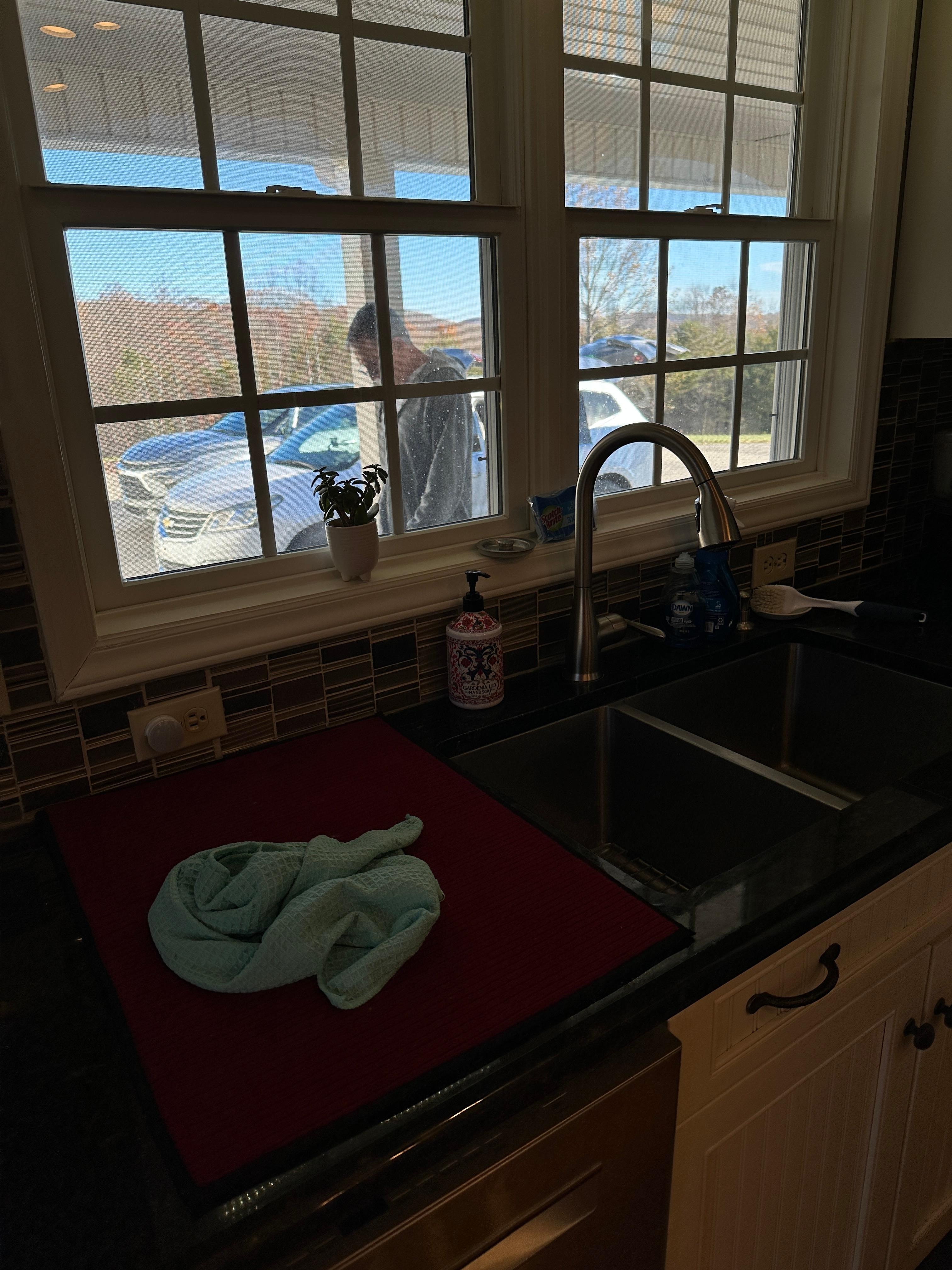 Renter passing the open window, of which there were no blinds, straight into the kitchen