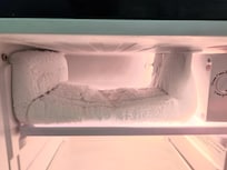 Freezer in mini-fridge, layers of 'snow' & no door on freezer.