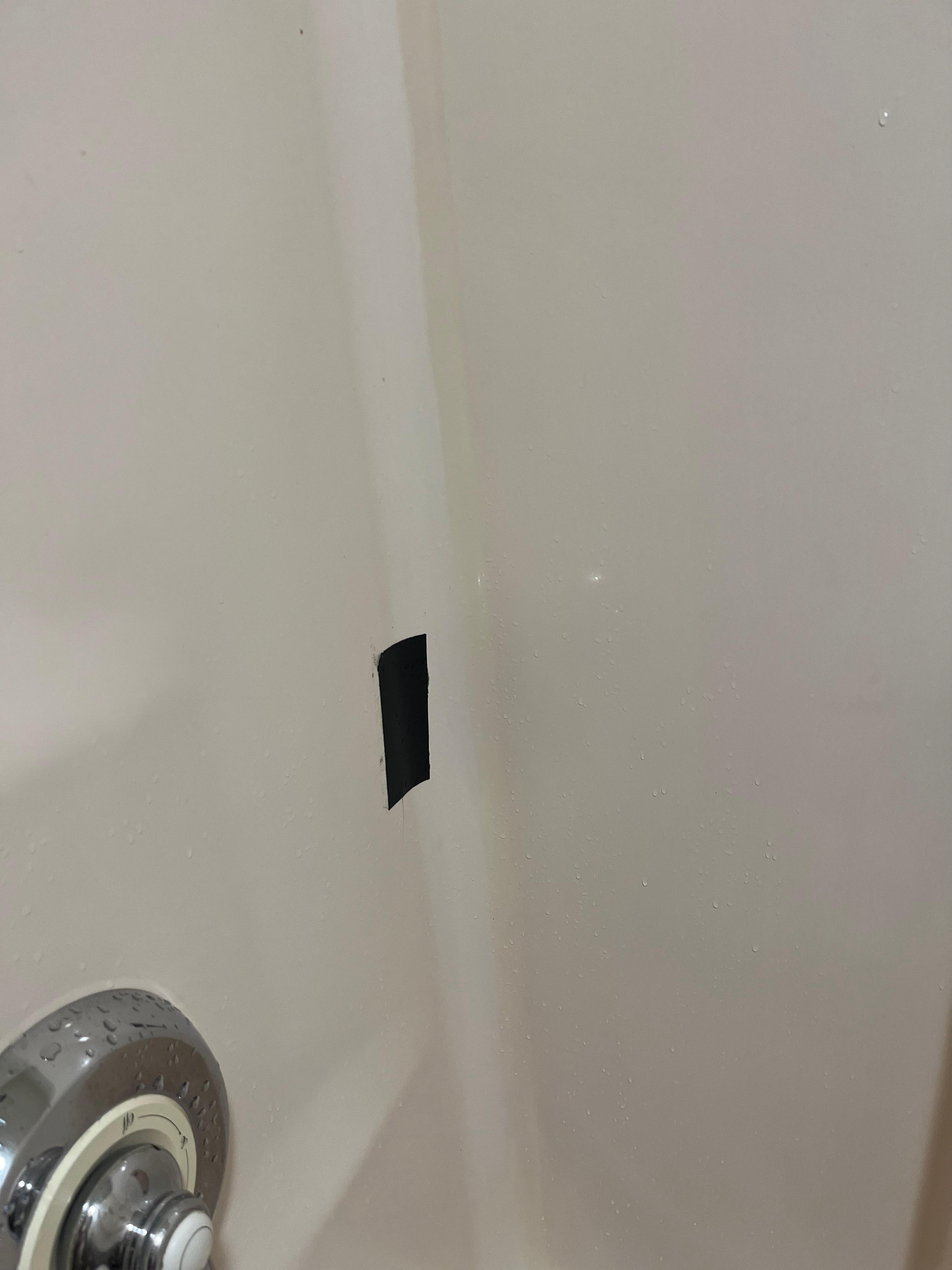 hole in shower wall repaired with duct tape