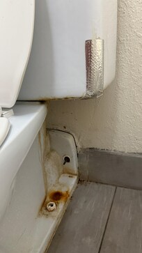 General dirtiness on the toilet and duct tape repairs.