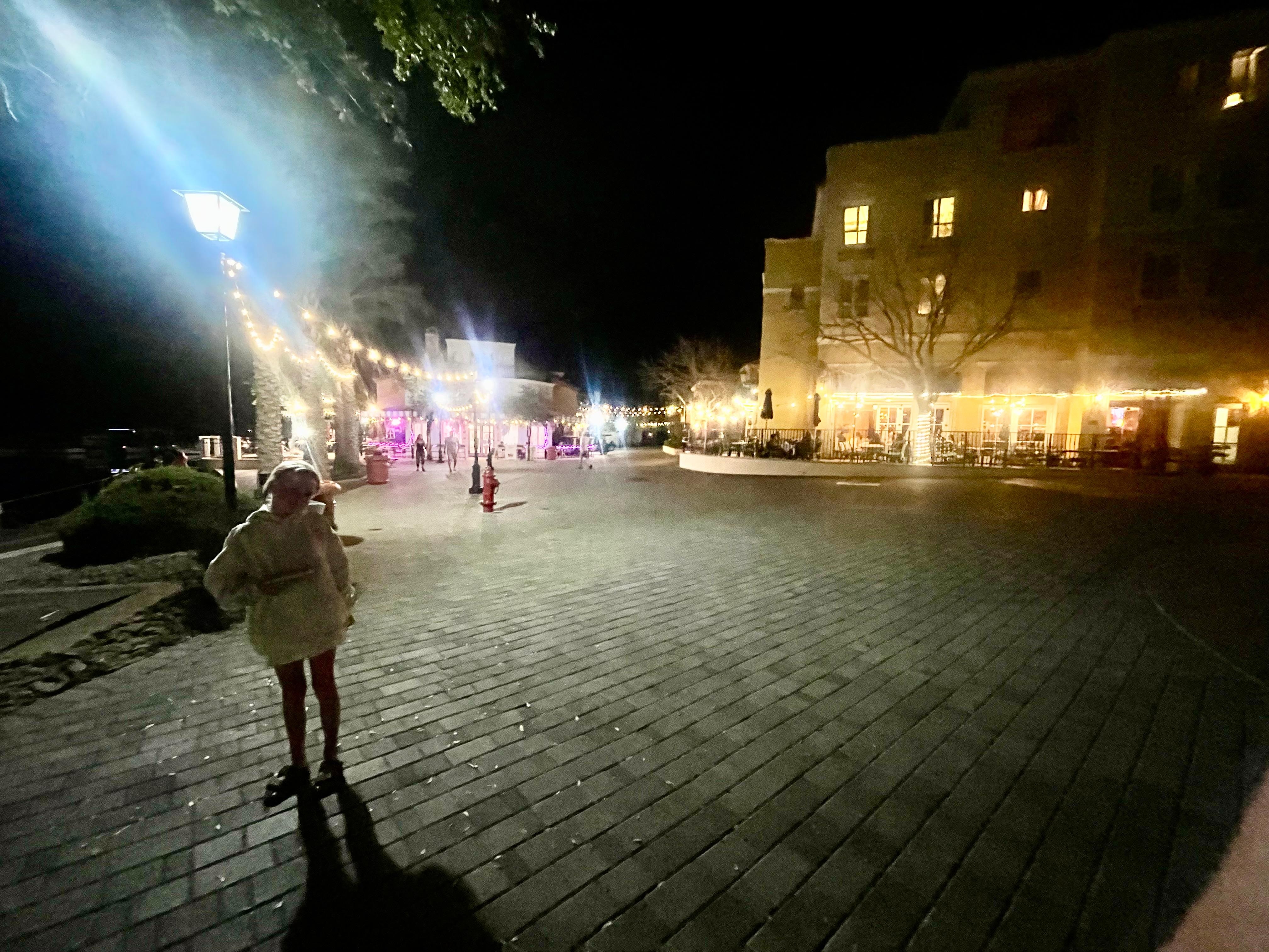 Dark but boardwalk by restaurants at night.
