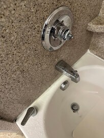 Mixer handle and water that splashed off the faucet onto side of tub and from there to floor