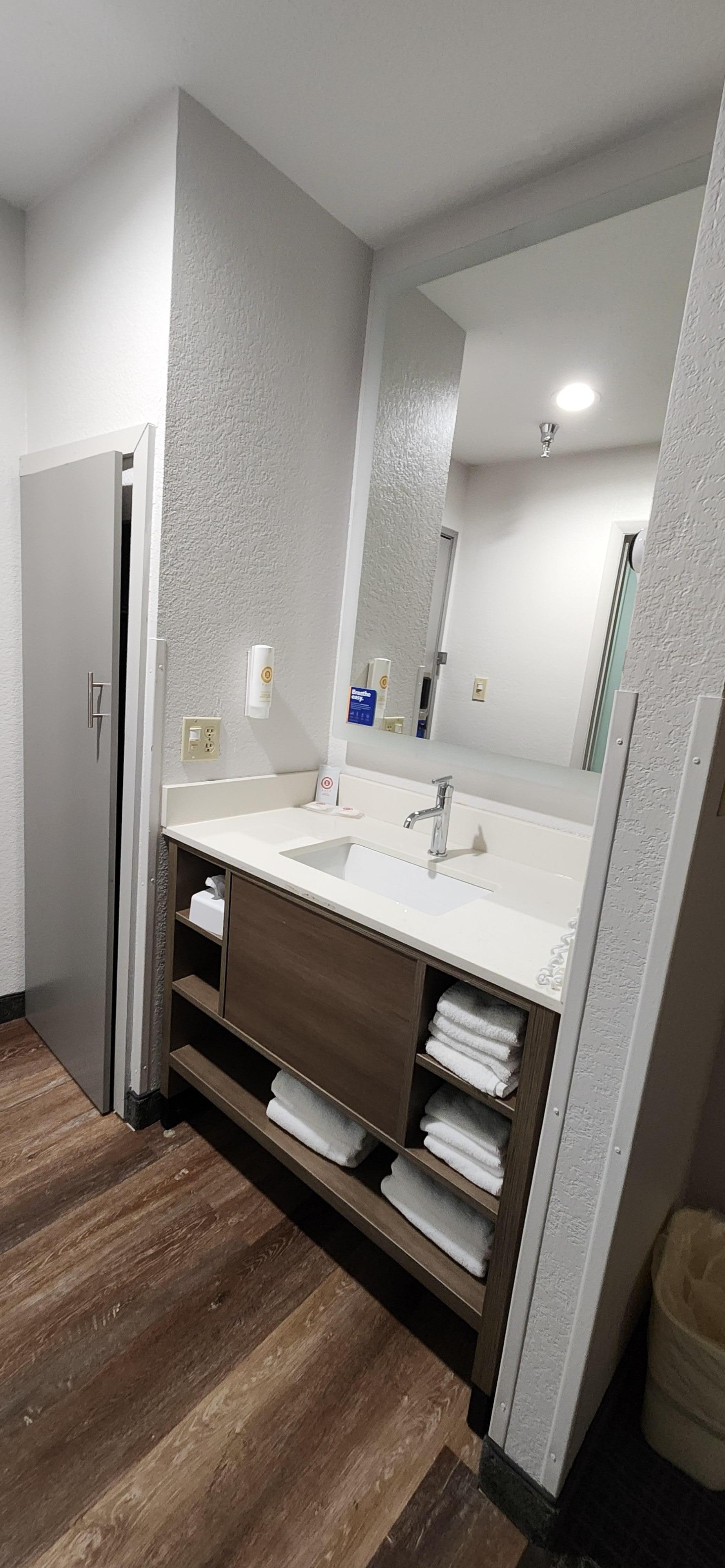 Sink with great light, mirror and closet with iron and ironing board