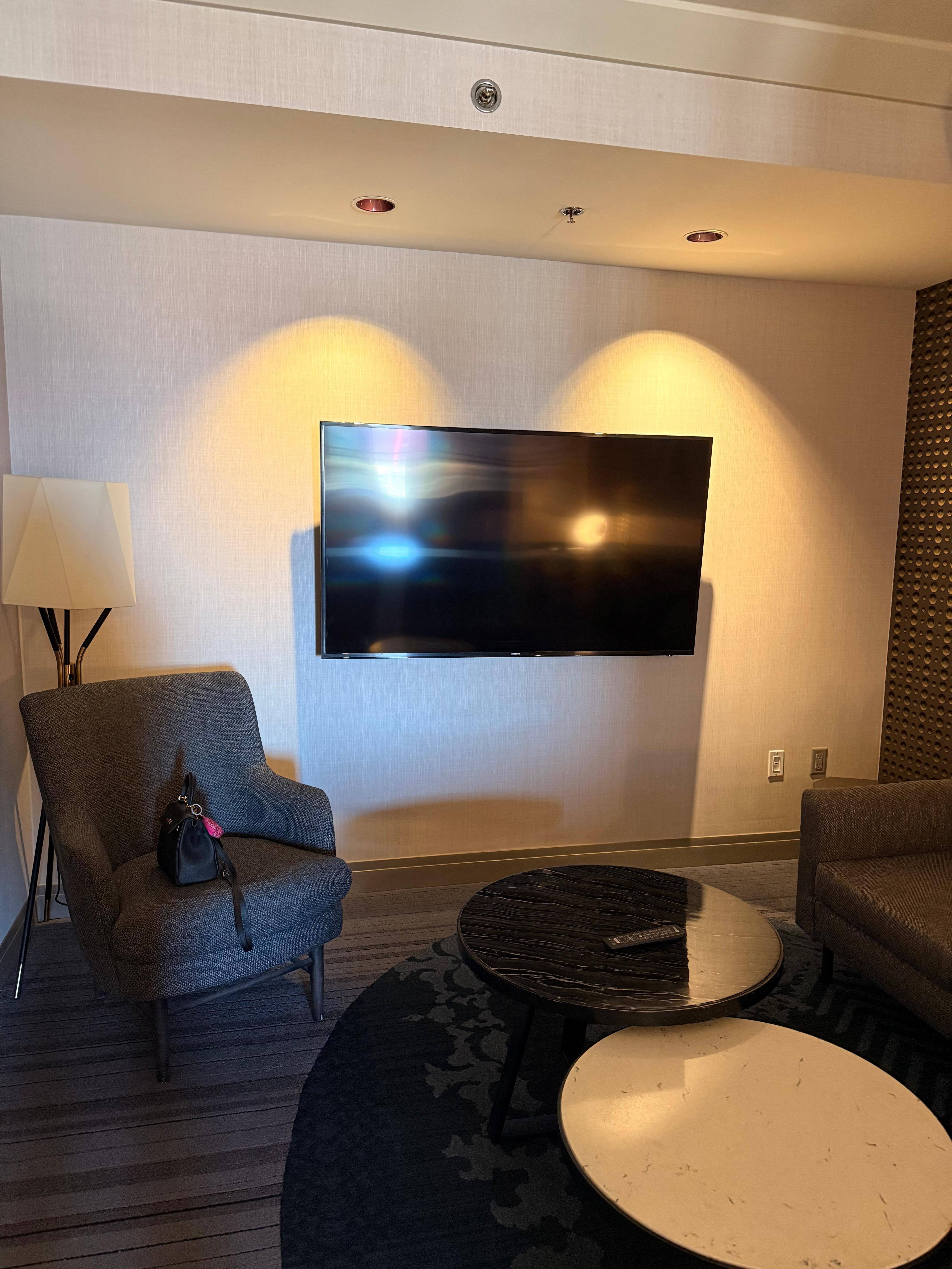 Sitting area with large sectional couch, chair, mounted tv. There is also a TV in the bedroom. 