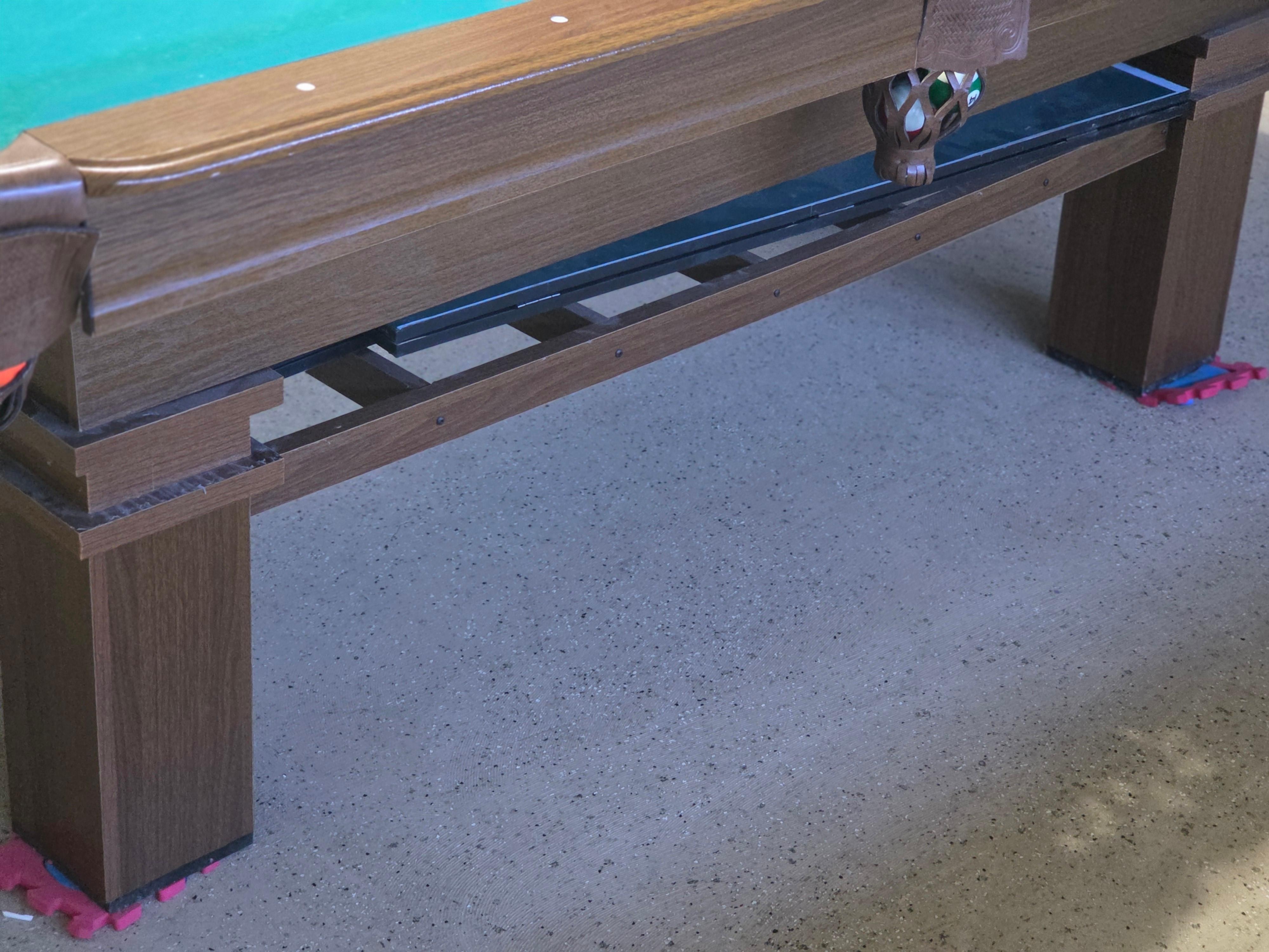 Pool table is uneven, held up by children puzzle pieces.