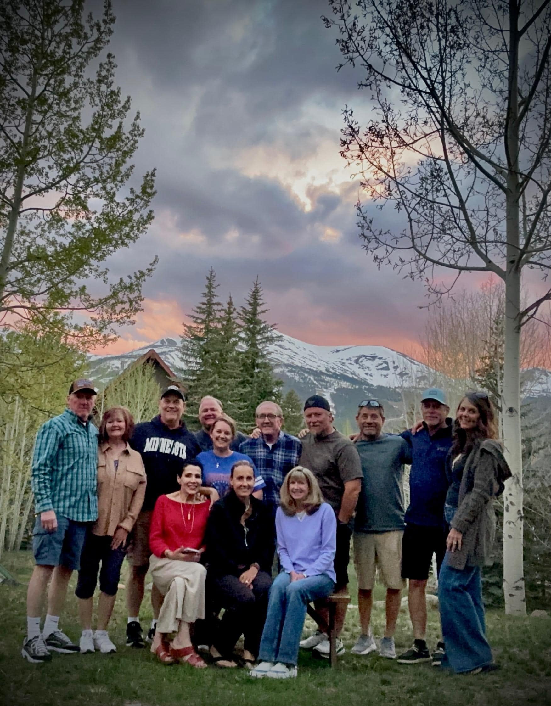 Group Photo in front of house with Breckinridge Ski Resort and sunset in the background.