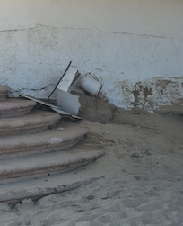 Garbage on beach by lounge chairs