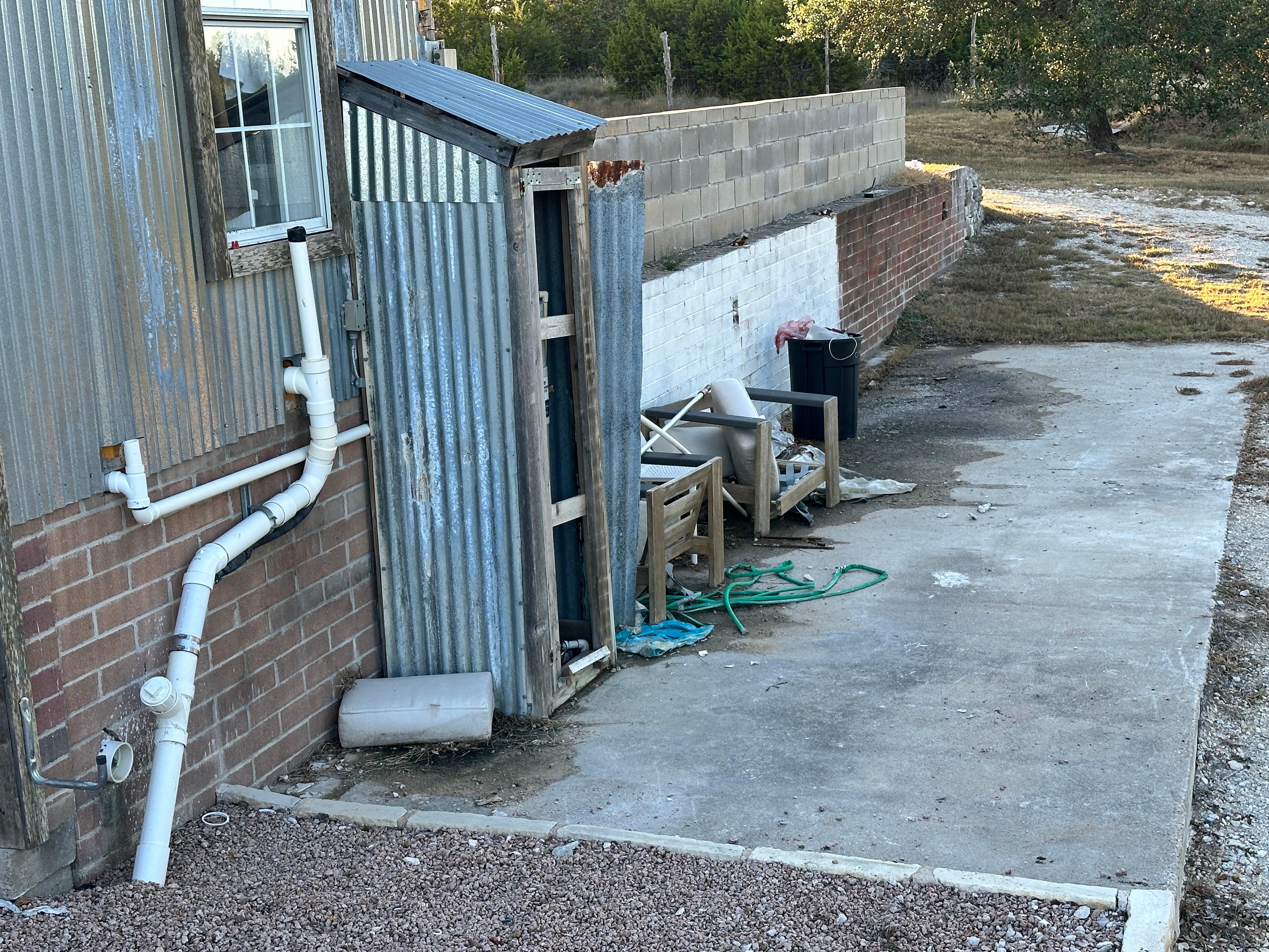 Back side of cottage closest to house full of trash