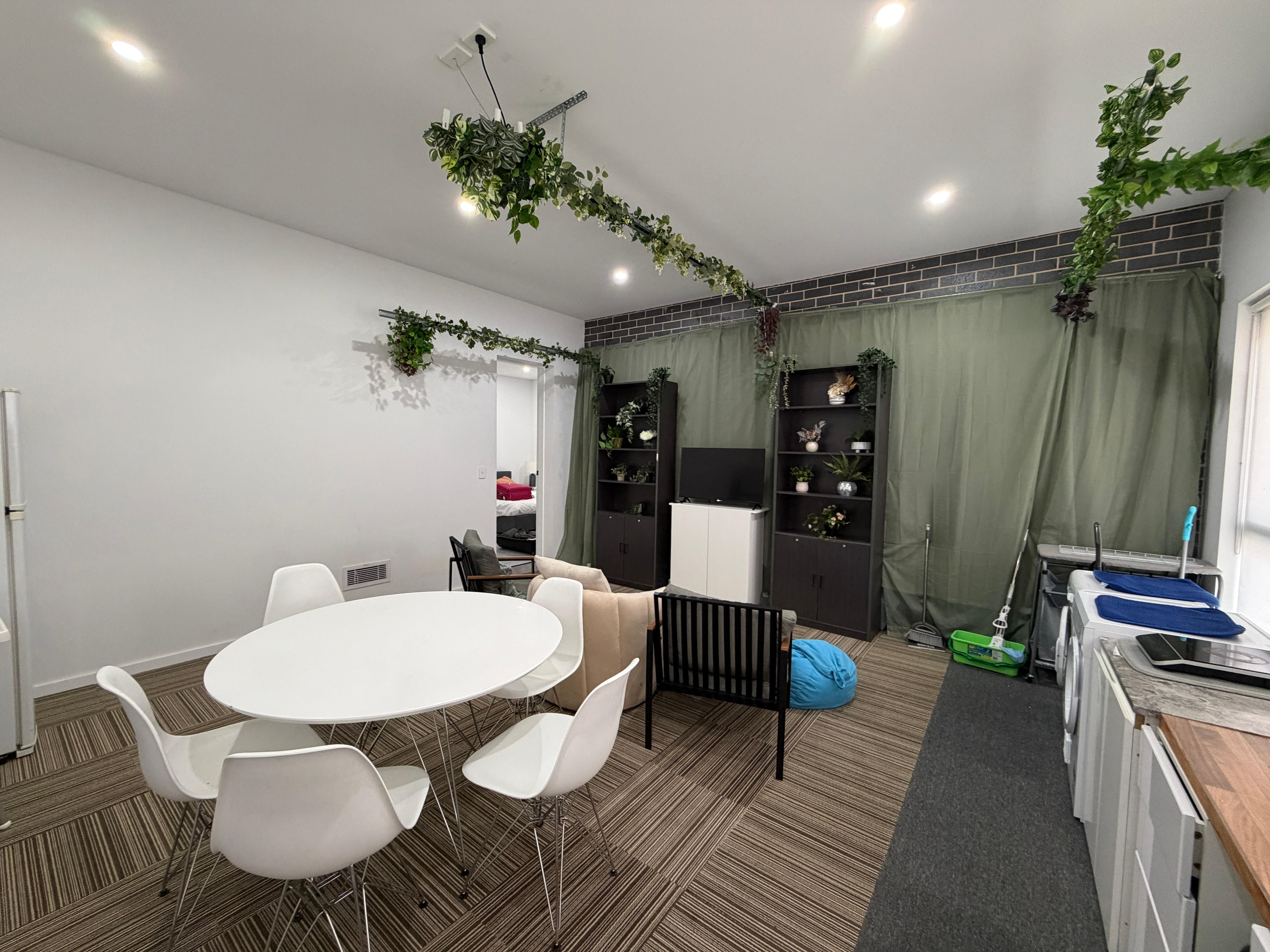 The living, kitchen, dining. The garage door is behind the green curtain.