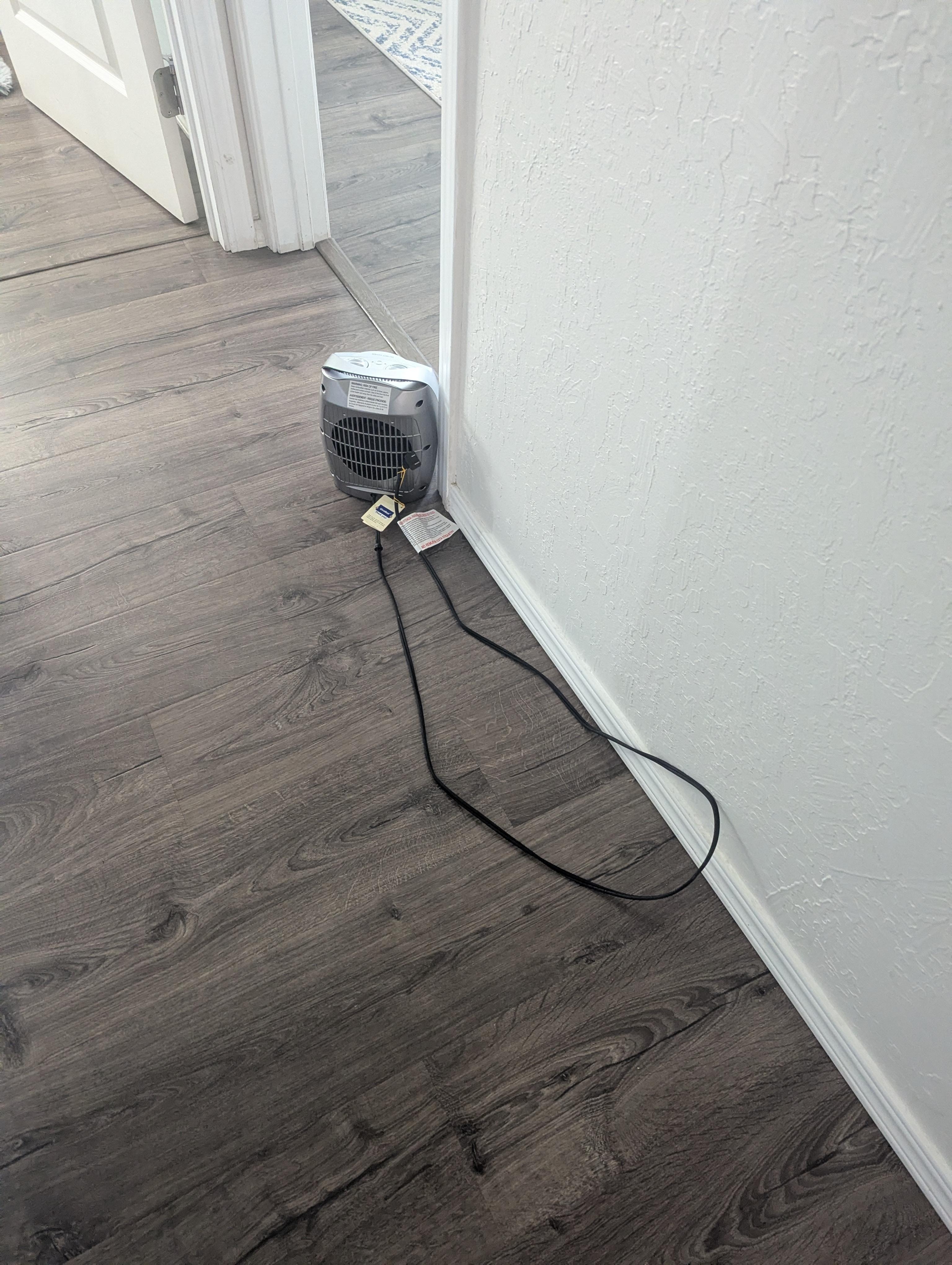 Heater plugged into hallway aimed towards back bedroom