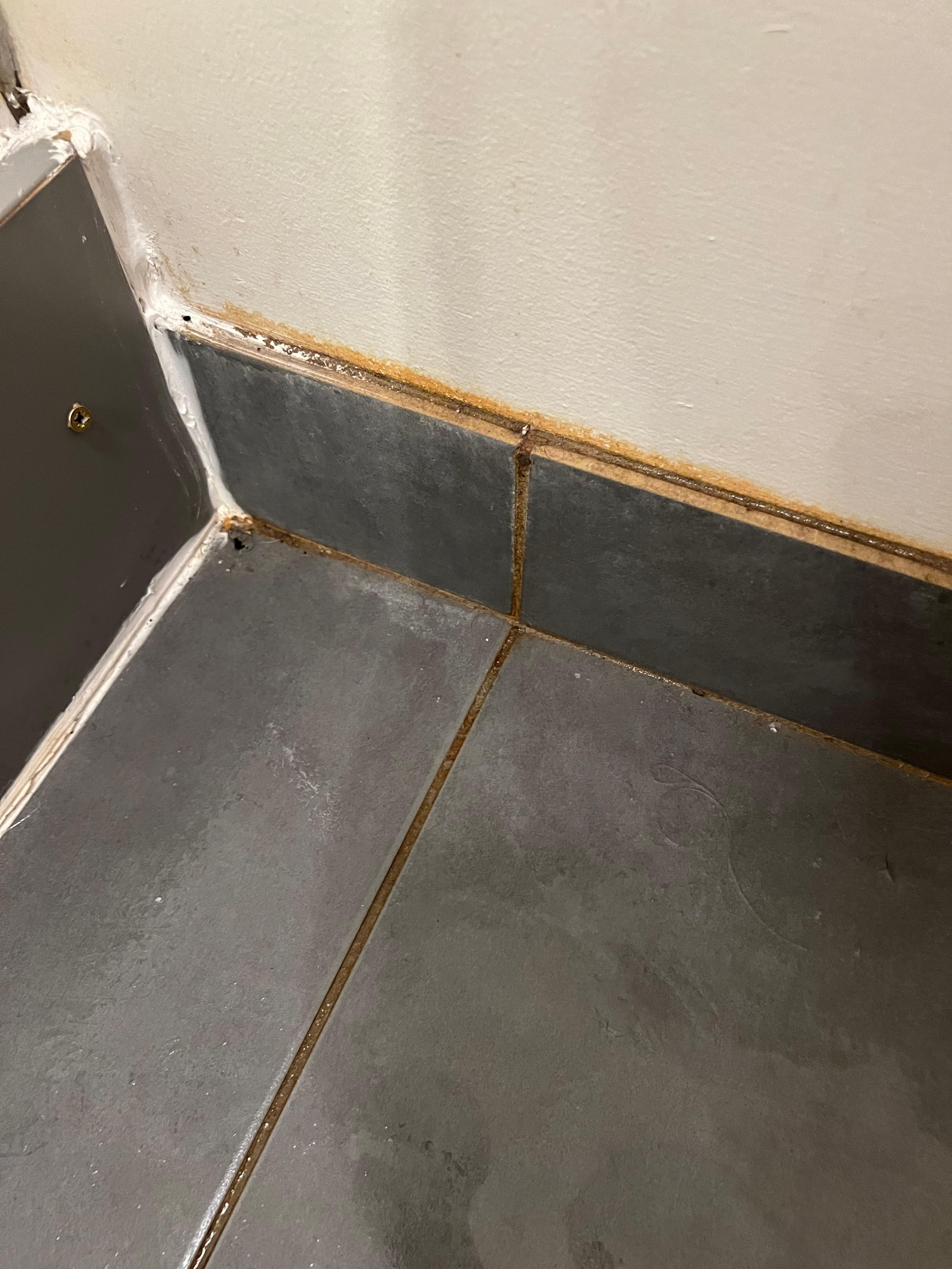 Bathroom grout so dirty that towel laid over picked up brown stain stripes 