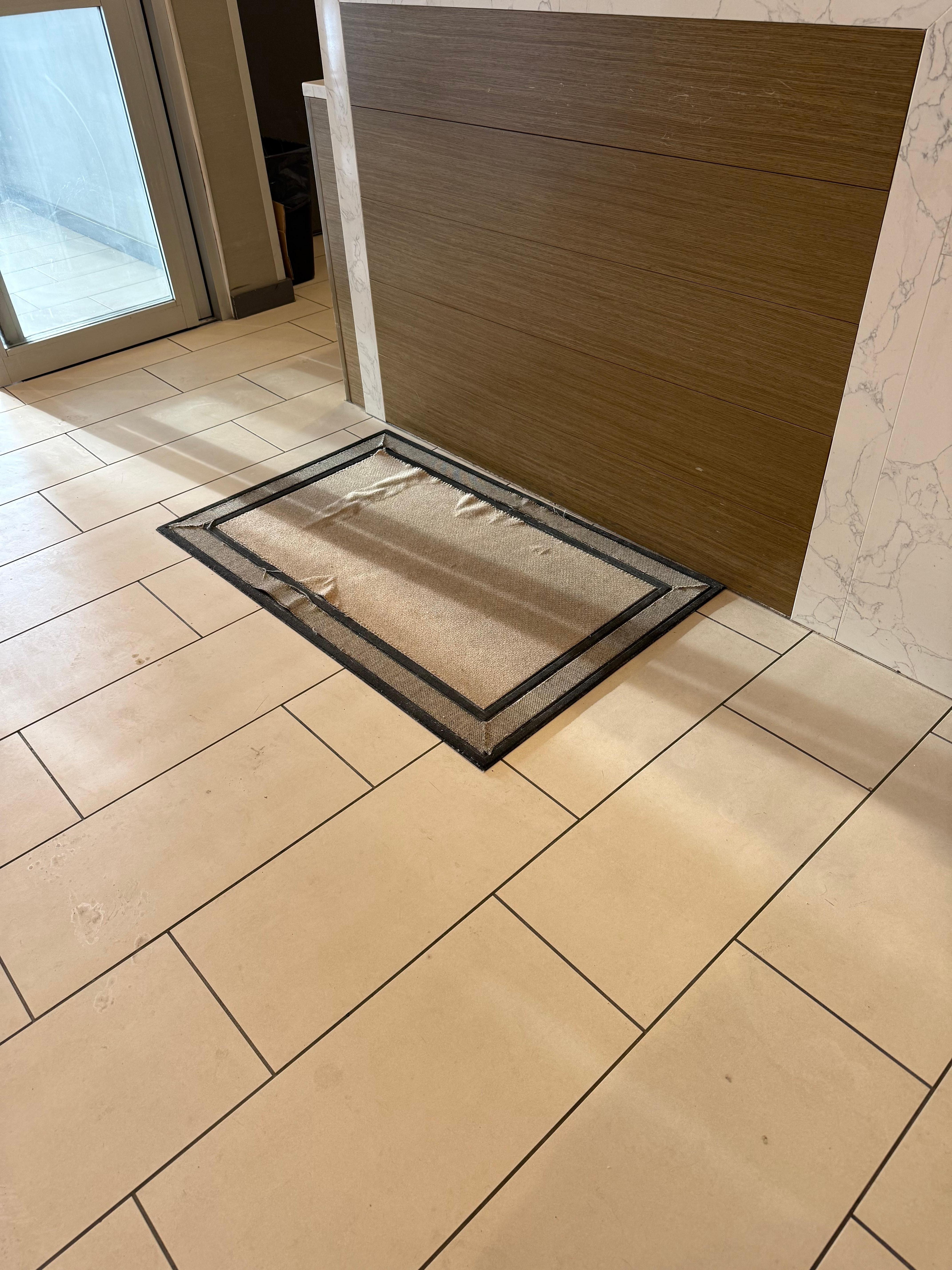 Ripped rug at the front desk.