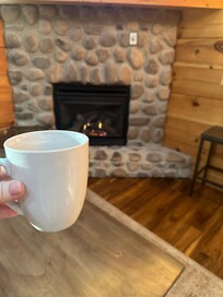 Drinking coffee in front of the fireplace.