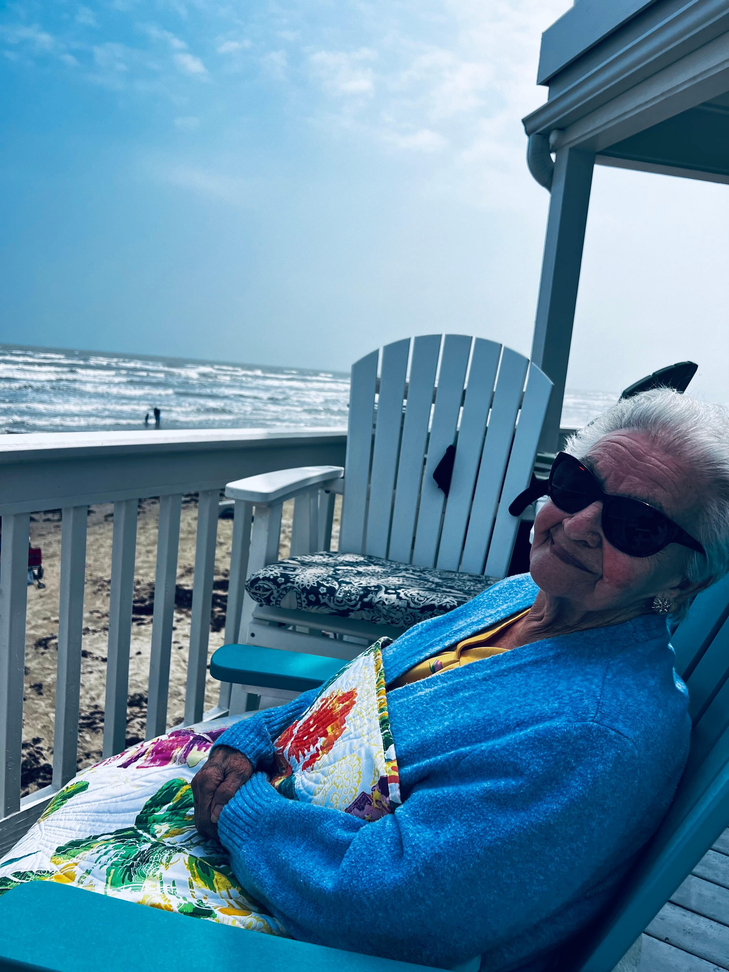 My 95yr old mom enjoying the beautiful day on the large deck overlooking the beach.