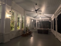 Back porch at night with one of the Xmas trees in the window.