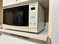 Vintage microwave in a dirty enclosure