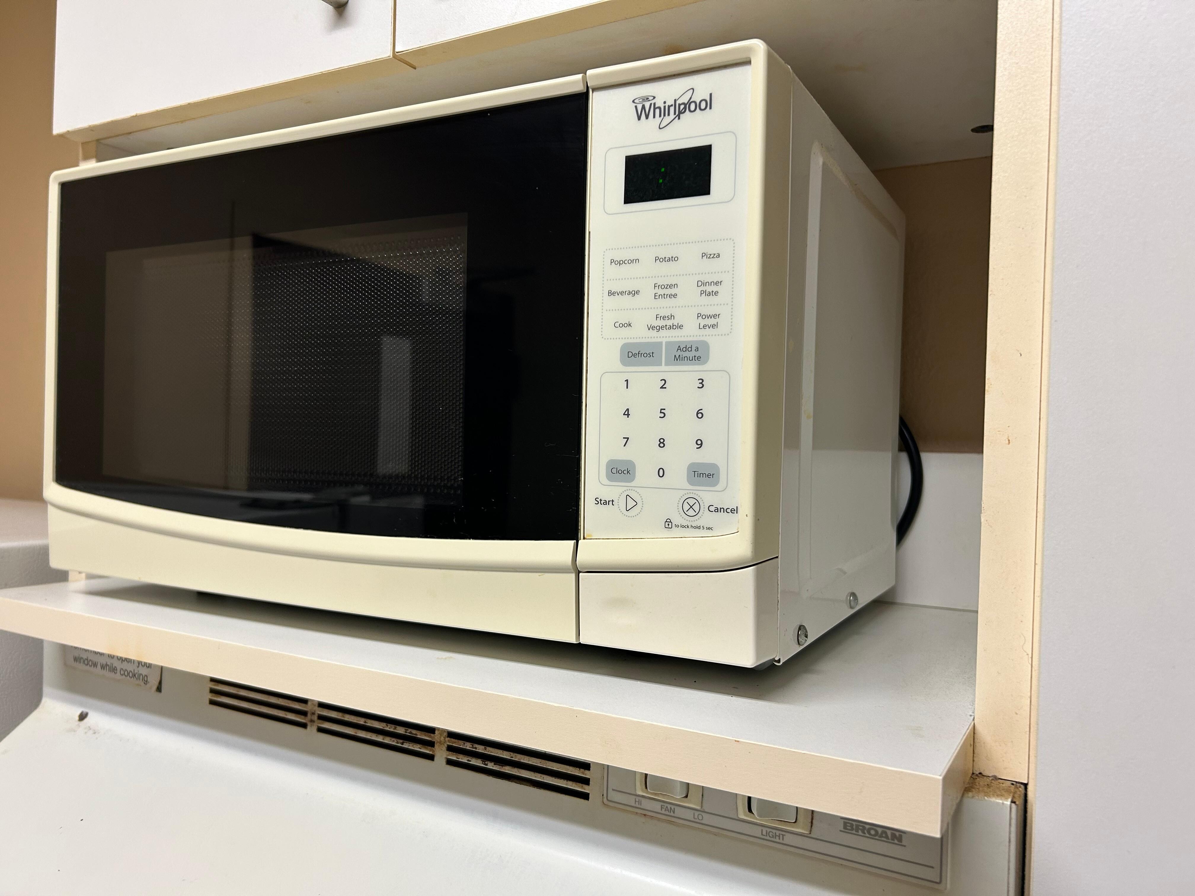 Vintage microwave in a dirty enclosure