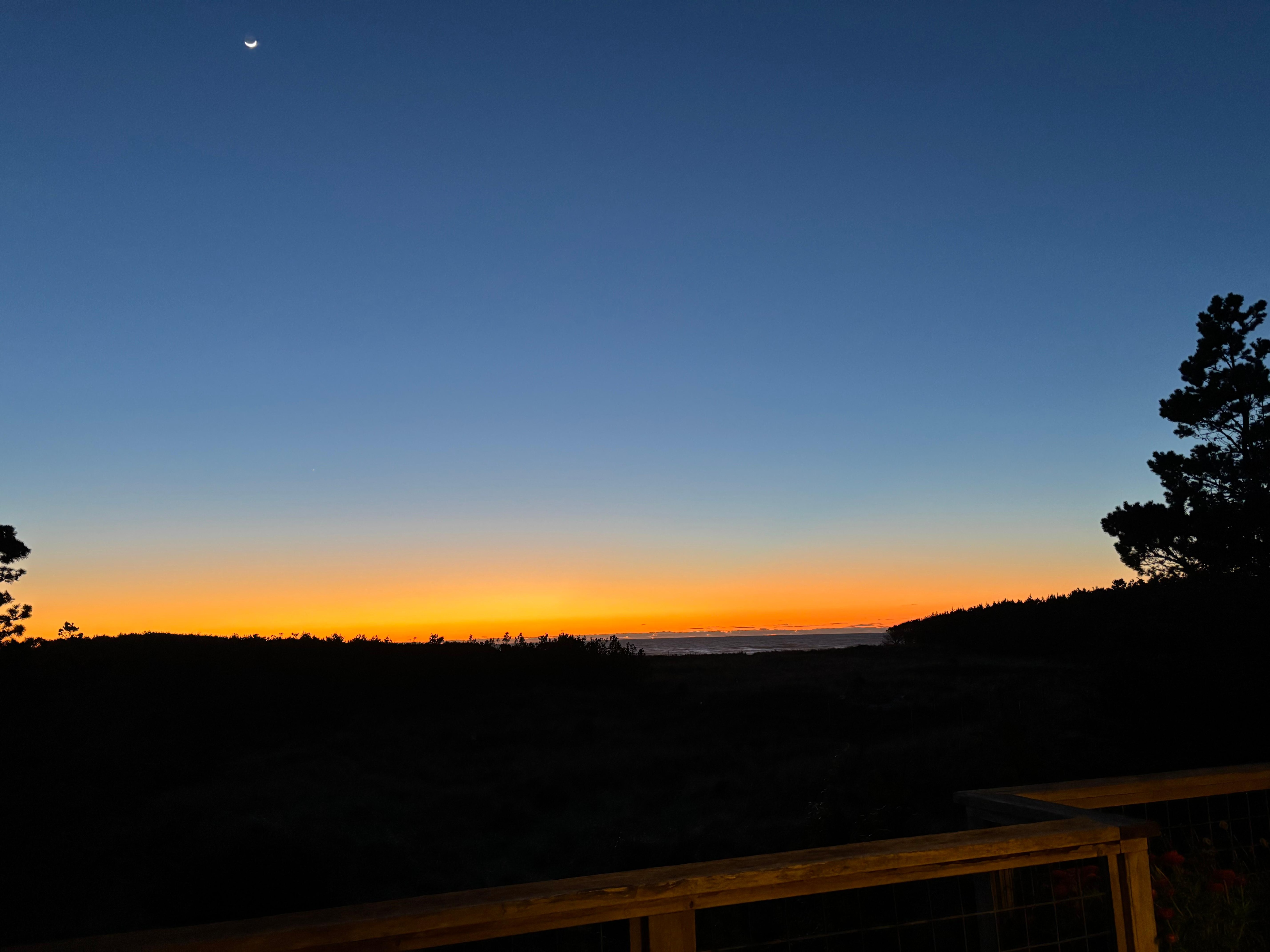 Moon above an ocean-view sunset from the wraparound balcony.