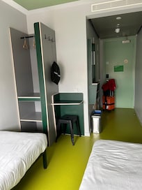 Twin bed. Closet with shelves. Desk area with stool.