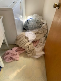 Dirty blankets piled in front of laundry--no outside clean linen service provided.