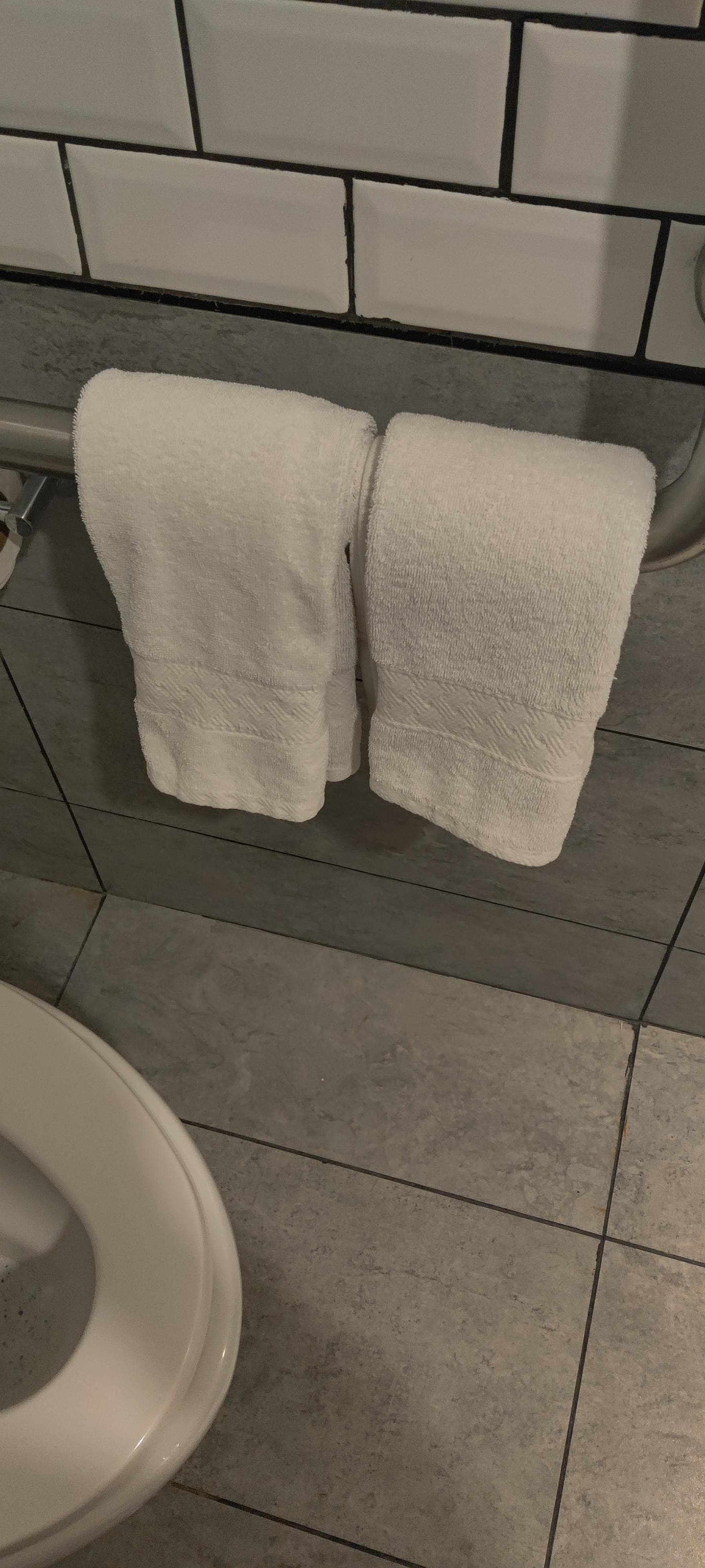 Face towels on grab bar next to toilet
